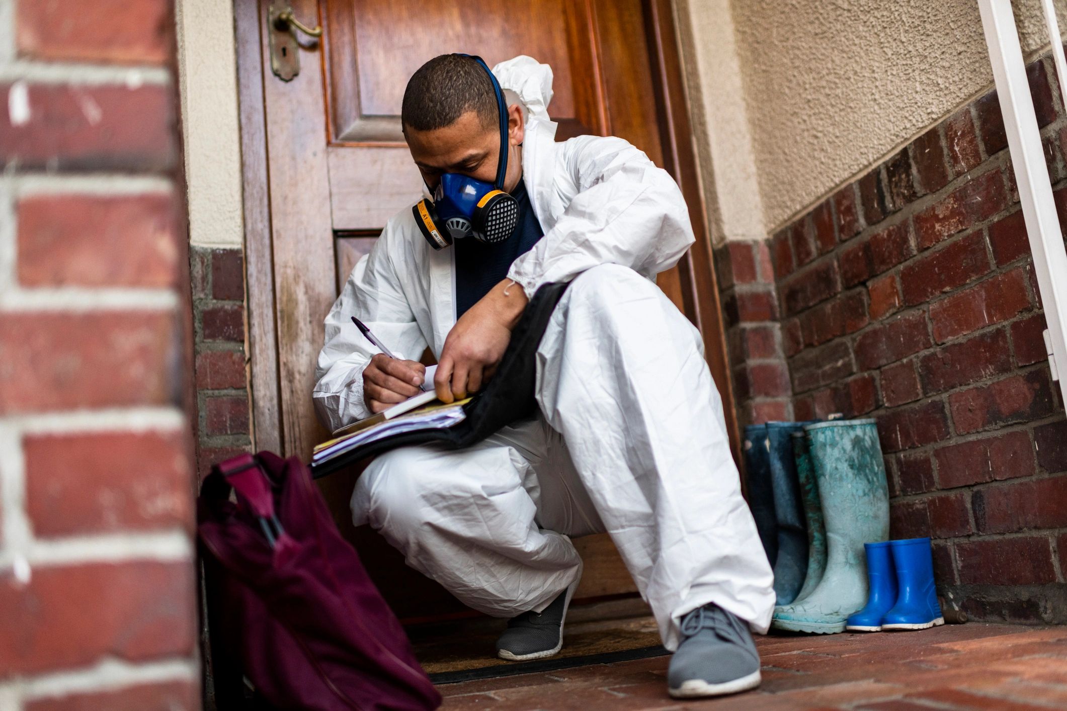 Technician in PPE completing documentation after a remediation visit
