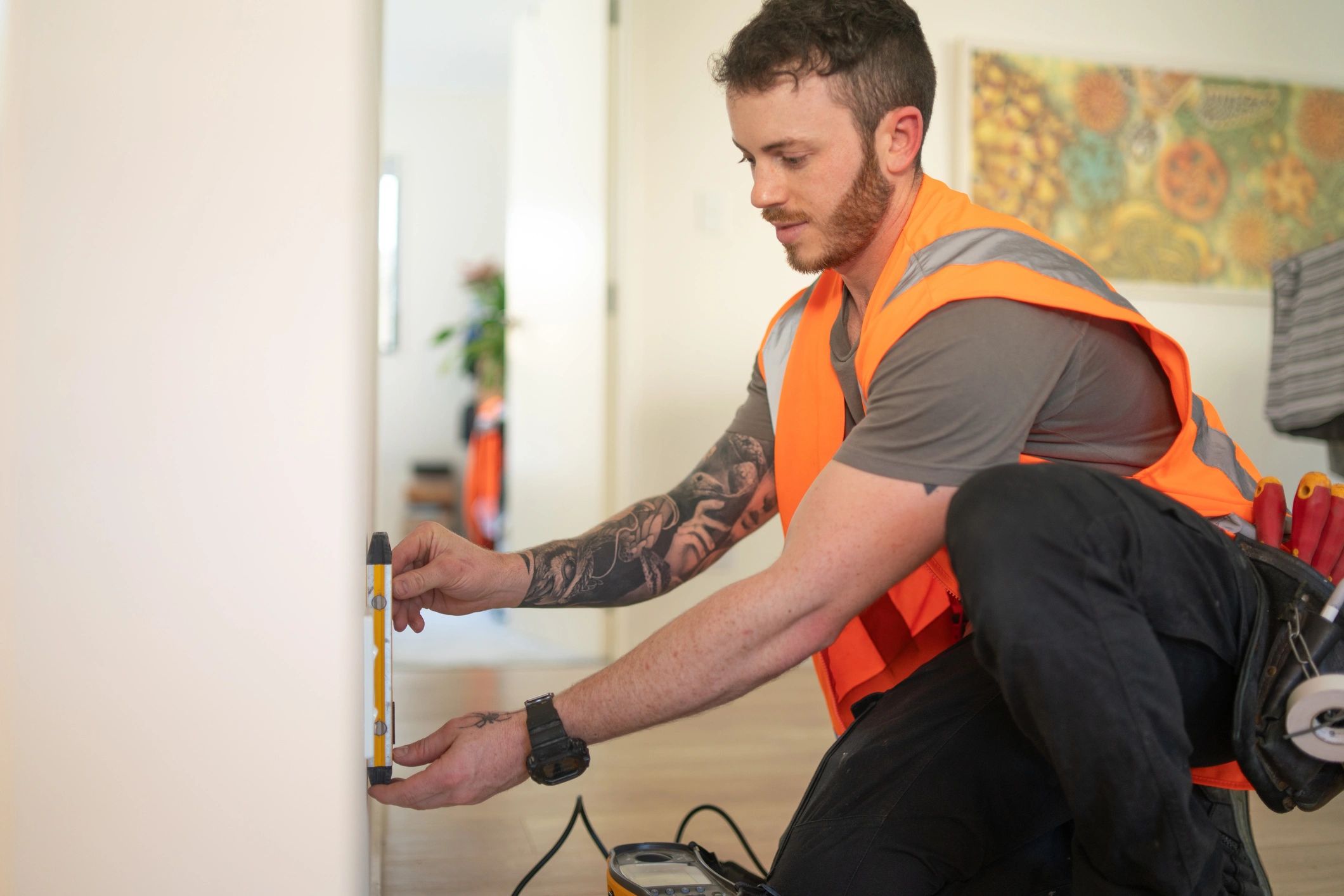 Technician using a level tool while repairing a wall during restoration work